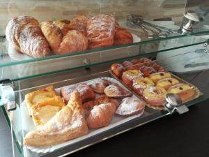 a display case with various types of breads and pastries at B&B Scirocco House in Oliveri