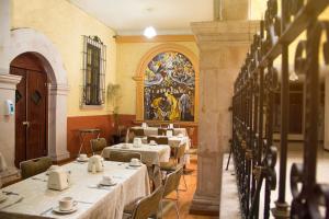 a dining room with tables and chairs and a painting on the wall at Hotel Maria Benita in Zacatecas