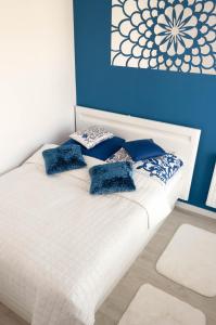 Una cama blanca con almohadas azules encima. en Apartament Marzanna II, en Sandomierz