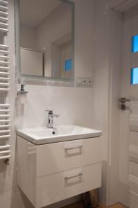 Baño blanco con lavabo y espejo en Apartament Marzanna II, en Sandomierz
