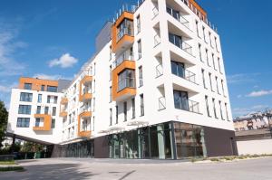 a white building with orange balconies on a street at Apartament Marzanna II in Sandomierz
