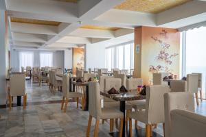 a dining room with tables and chairs and windows at Hotel Cartagena Dubai in Cartagena de Indias