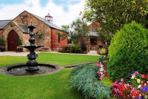 um jardim com uma fonte em frente a um edifício em The Mill Forge em Gretna Green