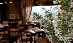 a restaurant with tables and chairs with white flowers at Αργουλιάς in Tzermiádon