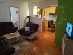 a living room with two chairs and a kitchen at Apartman Lidija in Livno +11 photos