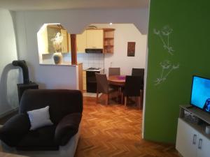 a living room with a chair and a dining room at Apartman Lidija in Livno