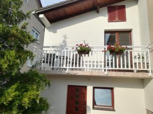 a white building with two potted plants on a balcony at Apartman Lidija in Livno