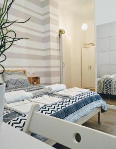 2 camas en una habitación con una pared a rayas en Los Patios de la Caleta, en Cádiz
