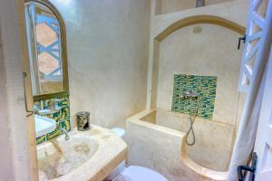 y baño con bañera y lavamanos. en Riad Dar Latigeo, en Essaouira
