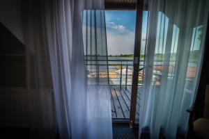 Blick auf einen Balkon von einem Fenster mit Vorhängen in der Unterkunft Hotel Rudnik in Graudenz