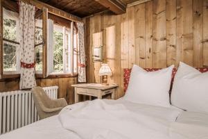 a bedroom with a bed and a table and windows at Berghütte - Schwaz - Pillberg in Pill