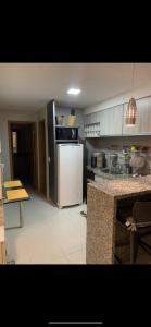 a kitchen with a white refrigerator and a counter at Cupe beach living in Porto De Galinhas