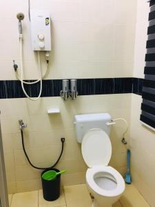 uma casa de banho com um WC branco numa cabina em ABAH HOMESTAY Kuala Terengganu em Kuala Terengganu
