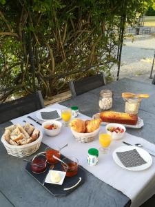 a table with bread and baskets of food on it at La Clé du Puy in Cabariot