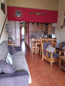 ein Wohnzimmer mit einem Sofa und einem Tisch in der Unterkunft CASA RURAL GREDOS in San Martín de la Vega del Alberche