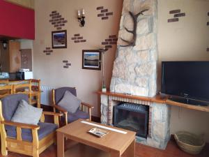 un salon avec une cheminée et une télévision dans l'établissement CASA RURAL GREDOS, à San Martín de la Vega del Alberche
