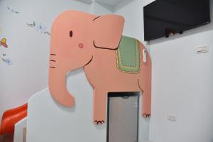 un gran elefante rosa parado sobre una puerta en Kids Heart Home en Fengyuan