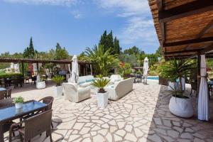 un patio con sillas, mesas y una piscina en Hotel Rural Cas Pla, en Sant Miquel de Balansat