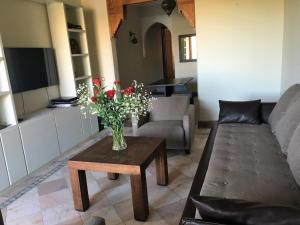 uma sala de estar com um vaso de flores sobre uma mesa em Luxury Celine Appart em Marrakech