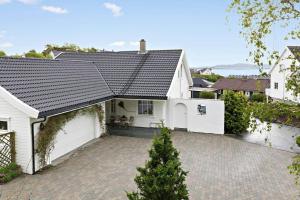 a white house with a garage and a driveway at Family house close to the beach in Mosterhamn