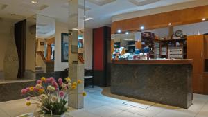 a lobby with a counter with flowers in a vase at Hotel Viena in Córdoba