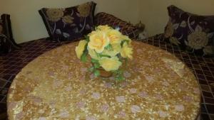 a vase with yellow flowers sitting on a table at Auberge de Tabhirte in Tahla
