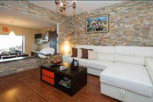 a living room with a white couch and a brick wall at NORTH CLIFF APARTMENT *The Ocean Beneath your Feet* in Gáldar