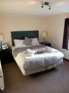a bedroom with a large bed with towels on it at The Swan Hotel in Almondsbury +5 photos