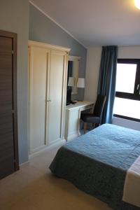 a bedroom with a bed and a desk and a chair at La Maison Rouge b&b in Ginosa Marina