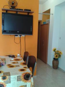 a dining room with a table with a television on the wall at Sea view apartman Antonio in Zadar