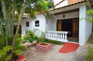 a white house with palm trees in front of it at Doce Lar Hospedaria in Lençóis