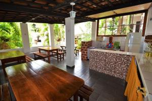 a kitchen with a table and some tables and chairs at Doce Lar Hospedaria in Lençóis