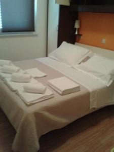 ein Bett mit weißen Handtüchern und Servietten darauf in der Unterkunft Sea view apartman Antonio in Zadar