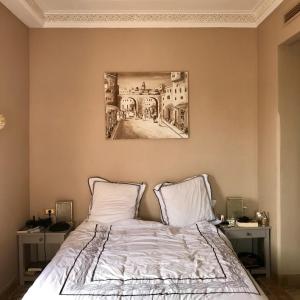 um quarto com uma cama com um quadro na parede em Luxury Celine Appart em Marrakech