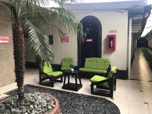 a lobby with green chairs and a palm tree at Hotel Imperial in Guayaquil