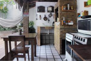 Hostel Itapua في سلفادور: مطبخ مع طاولة وموقد فرن علوي