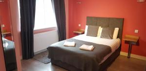 1 dormitorio con 1 cama con 2 toallas en Stansted Airport Lodge, en Takeley