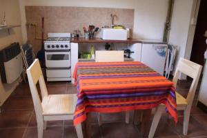 una cocina con una mesa con una manta de colores. en La Chakana de Uribelarrea en Uribelarrea