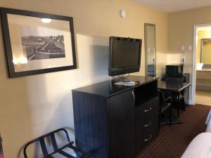 Pokój hotelowy z telewizorem na komodzie z biurkiem w obiekcie Emerson Inn - Jacksonville w mieście Jacksonville