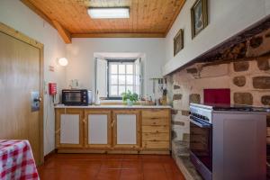a kitchen with a counter and a stove top oven at Casa do Retiro in Ponte de Lima