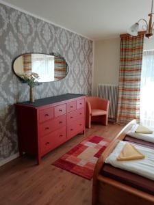 Tannenhof في سيمرنغ: غرفة نوم مع خزانة ملابس حمراء ومرآة