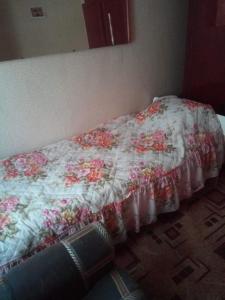 RubtsovskにあるApartment on Altaiskaia 181のベッド(花柄のキルト付)が備わる客室です。