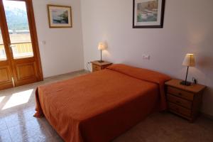 a bedroom with a bed with an orange bedspread at SOLIMAR 1 in Capdepera