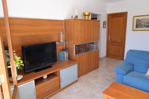 a living room with a tv and a blue chair at SOLIMAR 1 in Capdepera