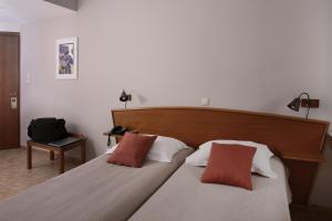a bedroom with a large bed with two pillows at Evripides Hotel in Athens