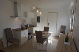 een keuken met een tafel en stoelen en een eetkamer bij Maison de standing avec jardin à 200m de la plage in Berck-sur-Mer