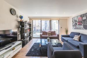 a living room with a blue couch and a tv at Lovely 2 Bed 2 Bath Apartment Central London in London