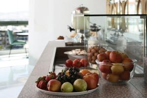 a table with bowls of fruit on a counter at Evripides Hotel in Athens