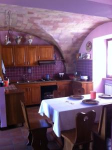 cocina con mesa y mantel blanco en CASCINA NELLA CAMPAGNA ABRUZZESE, en Isola del Gran Sasso dʼItalia