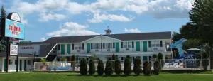 a building with a line of trees in front of it at Colonial motel in Wisconsin Dells